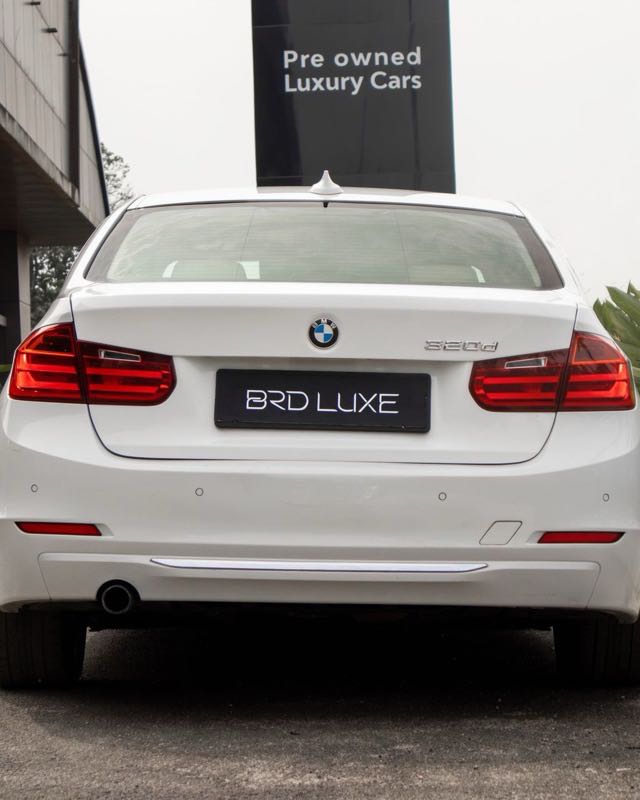 The rear of a white BMW 3 Series saloon on a dealer forecourt, with a 320d badge on the boot lid