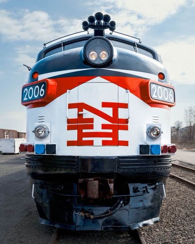 The white and red nose of a preserved New Haven EMD FL9 locomotive, number 2006, standing on a museum track