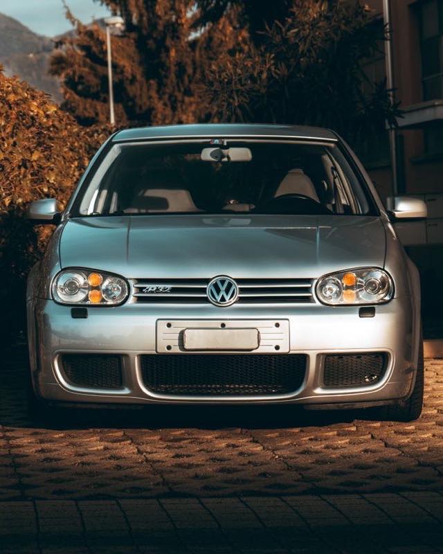 A silver Mk4 Volkswagen Golf R32 photographed head-on at dusk, R32 badge on the grille
