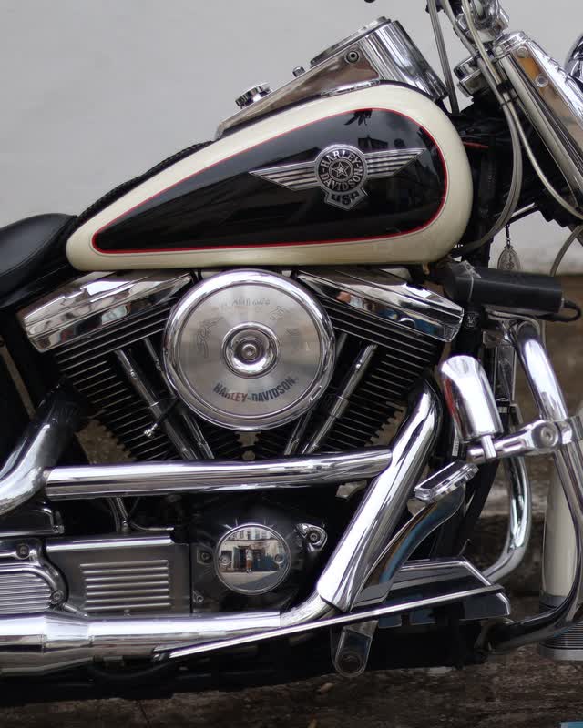 The 45 degree V-twin engine and fuel tank of a black and cream Harley-Davidson Heritage Softail, seen from the right